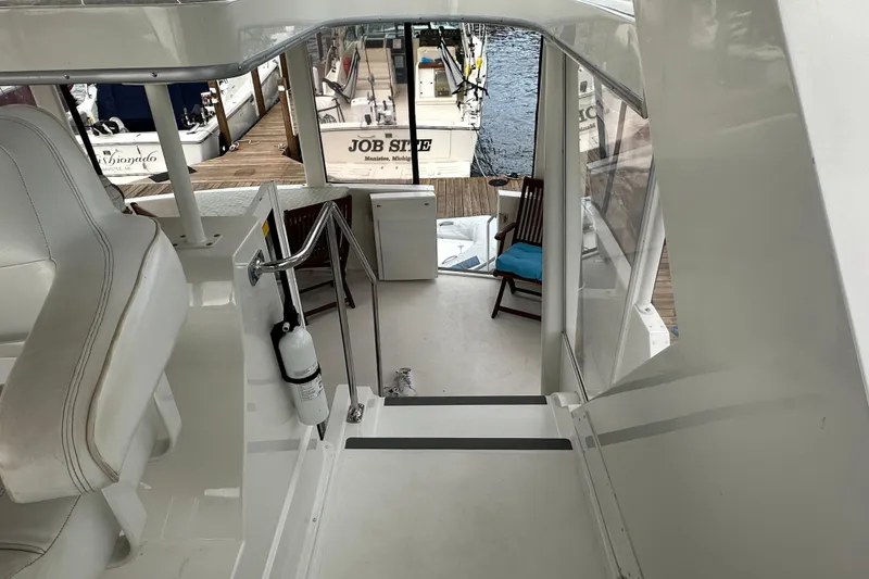 Slide: The Image of 1998 Carver 445 Aft Cabin Motor Yacht helm with white seating and controls. - 39