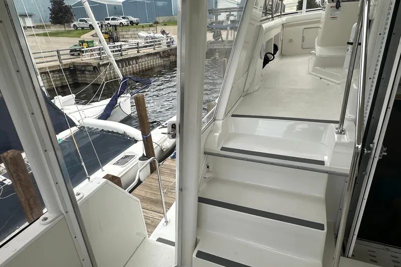 Slide: The Image of 1998 Carver 445 Aft Cabin Motor Yacht helm with white seating at marina. - 40