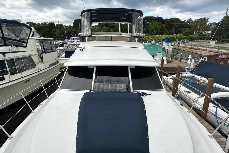 Slide: The Image of 1998 Carver 445 Aft Cabin Motor Yacht docked at marina under cloudy skies. - 17