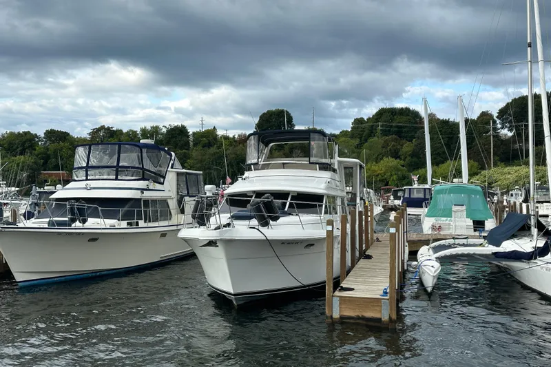 Slide: The Image of 1998 Carver 445 Aft Cabin Motor Yacht on trailer at marina, clear sky background. - 2