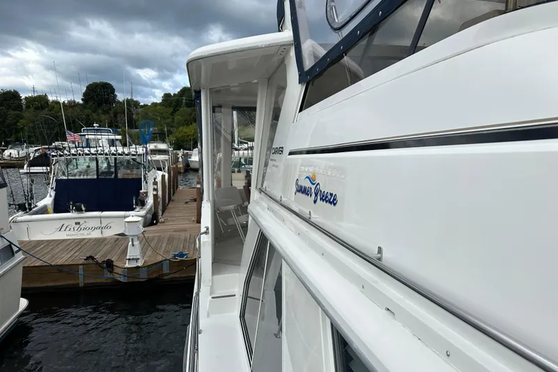 Slide: The Image of Inflatable boat with Mercury 9.9 motor docked beside 1998 Carver 445 Aft Cabin Motor Yacht. - 21