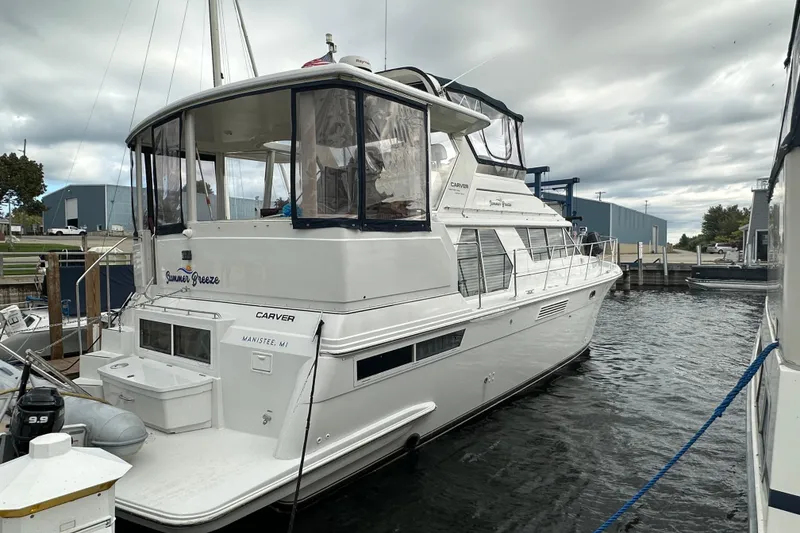Slide: The Image of 1998 Carver 445 Aft Cabin Motor Yacht docked at marina under clear blue sky. - 7