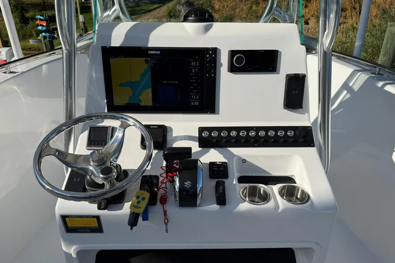 Slide: The Image of 2025 Cape Horn 22 OS boat dashboard with steering wheel and navigation controls. - 10