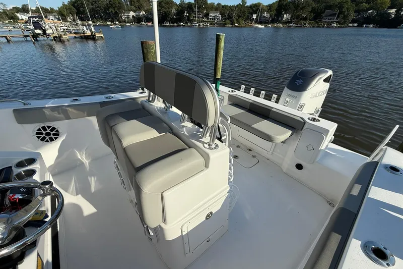 Slide: The Image of 2025 Cape Horn 22 OS boat interior with seating and Suzuki engine, docked by a serene lake. - 19