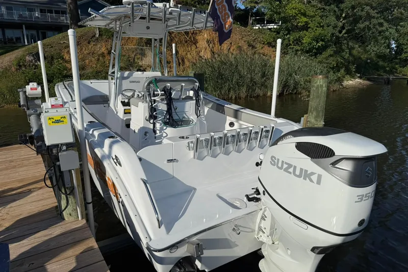 Slide: The Image of 2025 Cape Horn 22 OS boat with Suzuki 350 engine docked by a wooden pier. - 2
