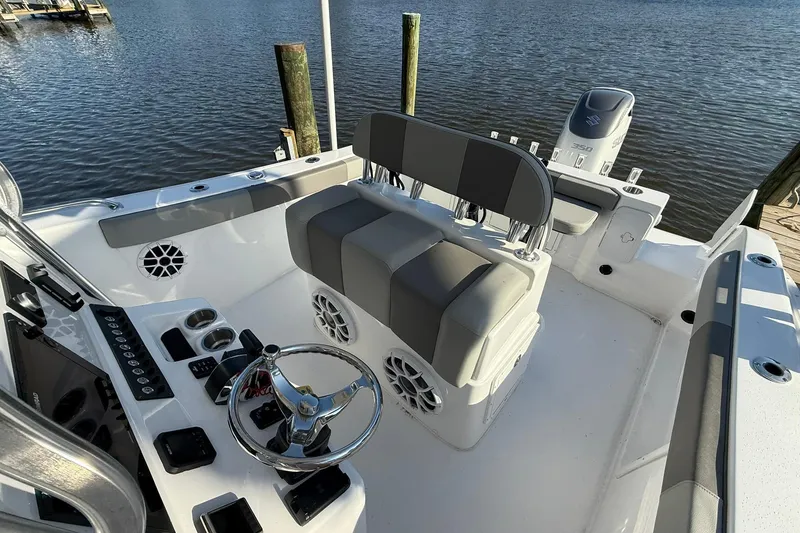 Slide: The Image of 2025 Cape Horn 22 OS boat interior with steering wheel and seating, docked by the water. - 8