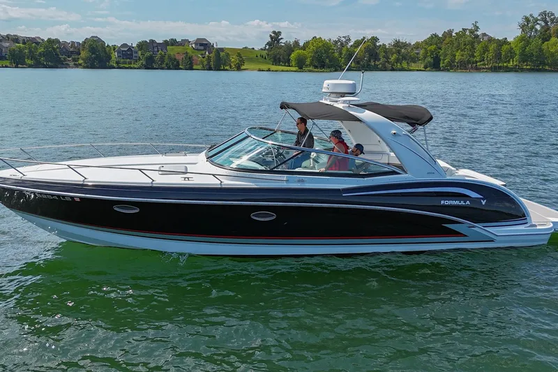 Slide: The Image of 2014 Formula 350 Sun Sport boat cruising on a scenic lake. - 10