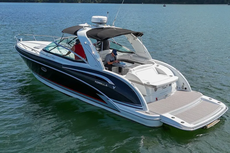 Slide: The Image of 2014 Formula 350 Sun Sport boat cruising on a serene lake. - 11