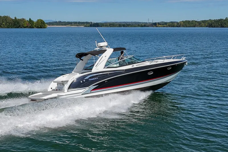 Slide: The Image of 2014 Formula 350 Sun Sport boat cruising on a lake under clear skies. - 2