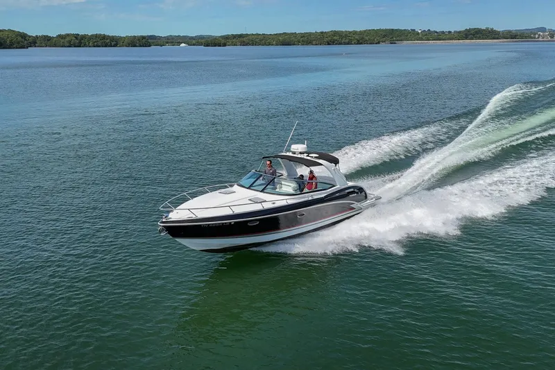 Slide: The Image of 2014 Formula 350 Sun Sport cruising on a serene lake with lush green surroundings. - 76