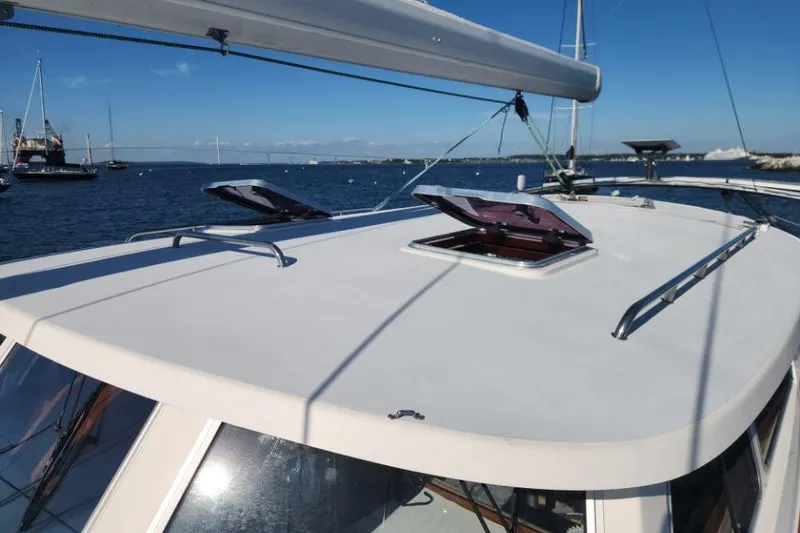 Slide: The Image of 2008 Bruckmann 50 MKII yacht deck with open hatches, moored in a scenic harbor. - 12