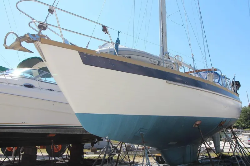 Slide: The Image of 1987 Slocum 43 sailboat on dry dock, blue and white hull, sunny day. - 2