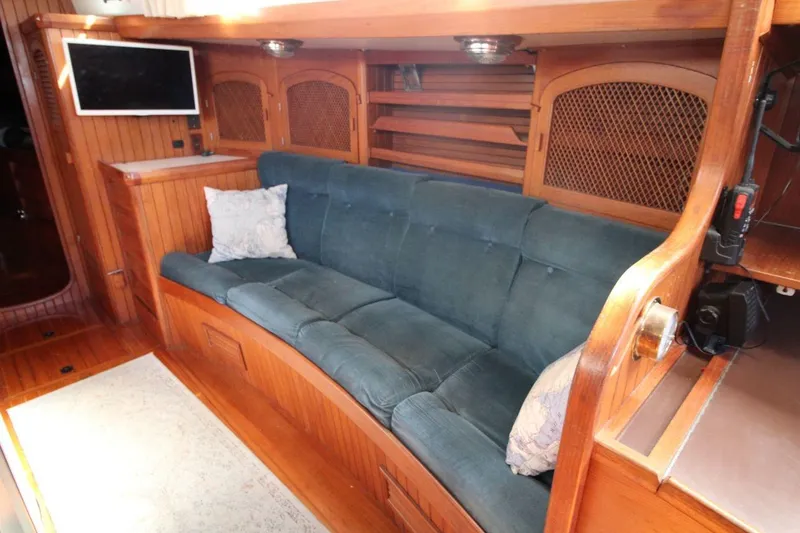 Slide: The Image of Interior of 1987 Slocum 43 yacht with blue sofa and wooden cabinetry. - 21