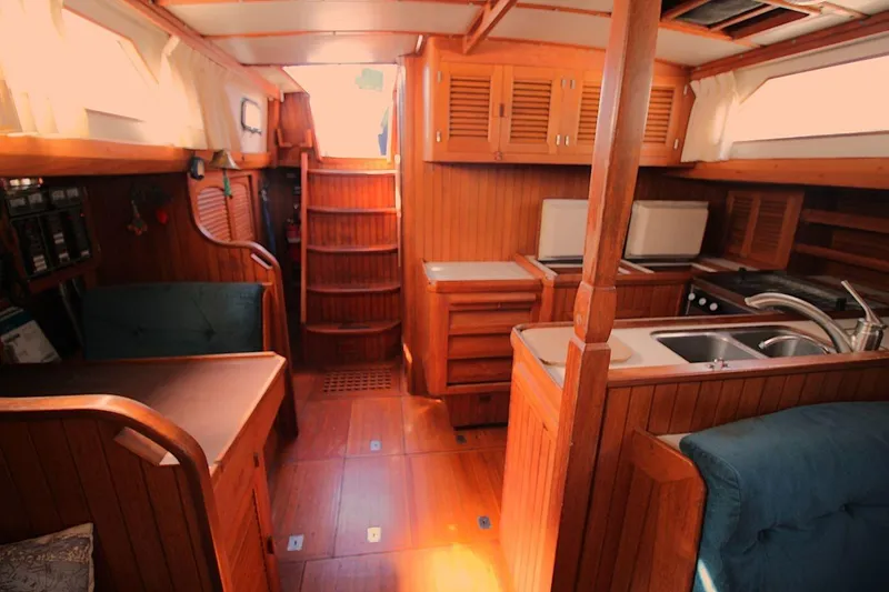 Slide: The Image of Interior of 1987 Slocum 43 sailboat with wooden cabinetry and compact kitchen area. - 26
