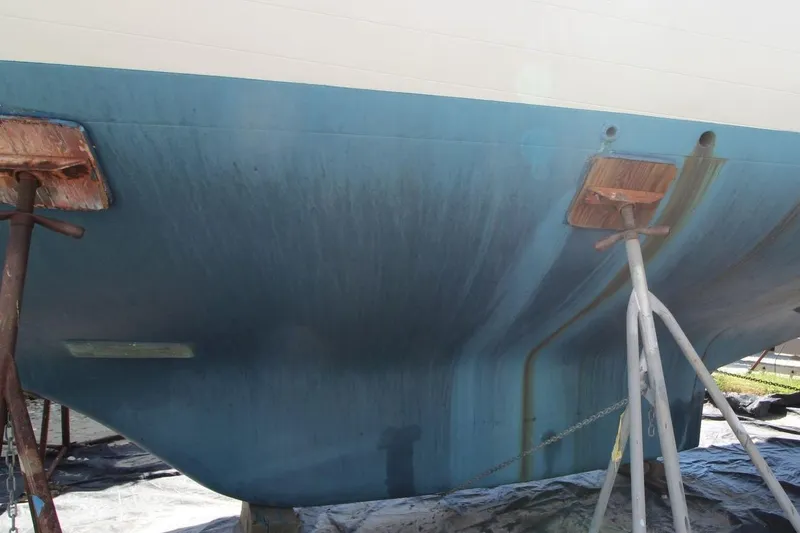 Slide: The Image of 1987 Slocum 43 sailboat hull on stands, showing blue paint and support structures. - 3