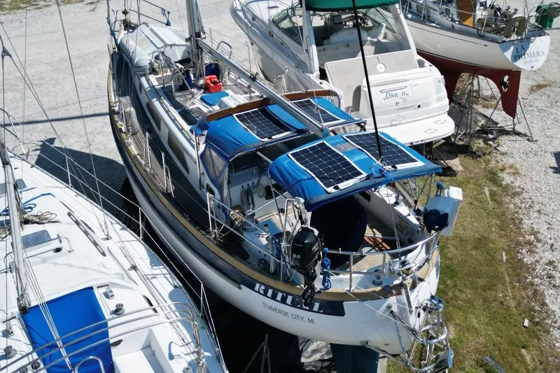 Slide: The Image of 1987 Slocum 43 sailboat with solar panels, docked among other boats. - 7
