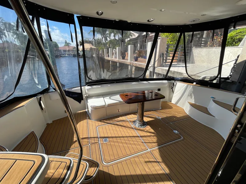 Slide: The Image of 2005 Carver 56 Voyager yacht interior with wood flooring and waterfront view. - 18