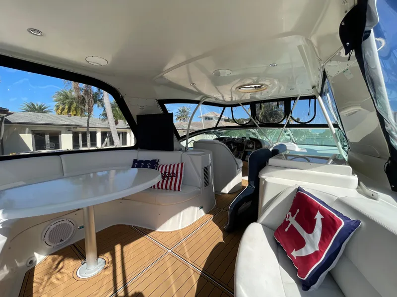 Slide: The Image of 2005 Carver 56 Voyager yacht interior with seating, table, and nautical-themed pillows. - 34