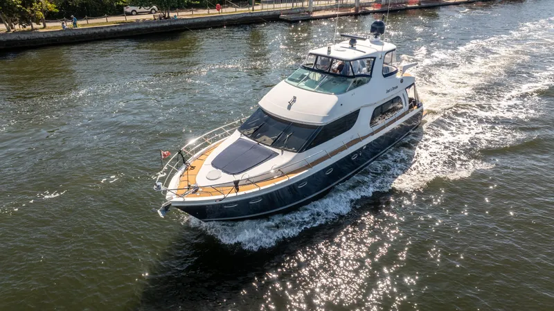 Slide: The Image of 2005 Carver 56 Voyager yacht cruising on a sunny waterway. - 4