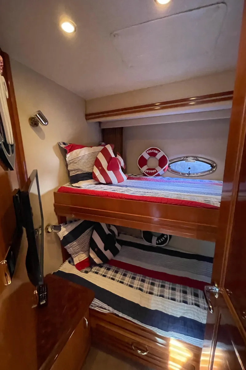 Slide: The Image of 2005 Carver 56 Voyager cabin with bunk beds, nautical decor, and wood finish. - 41