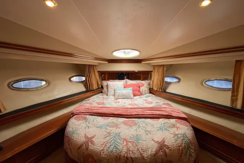 Slide: The Image of Luxurious bedroom interior of 2005 Carver 56 Voyager yacht with elegant bedding and porthole windows. - 42