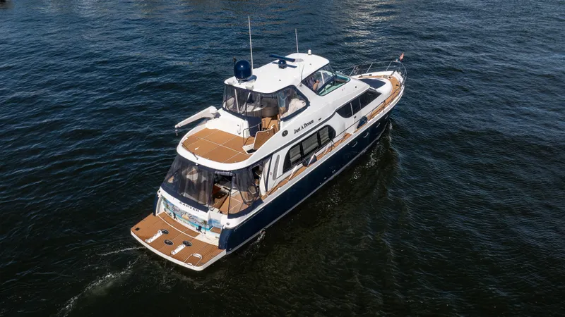 Slide: The Image of 2005 Carver 56 Voyager yacht cruising on open water, aerial view. - 5