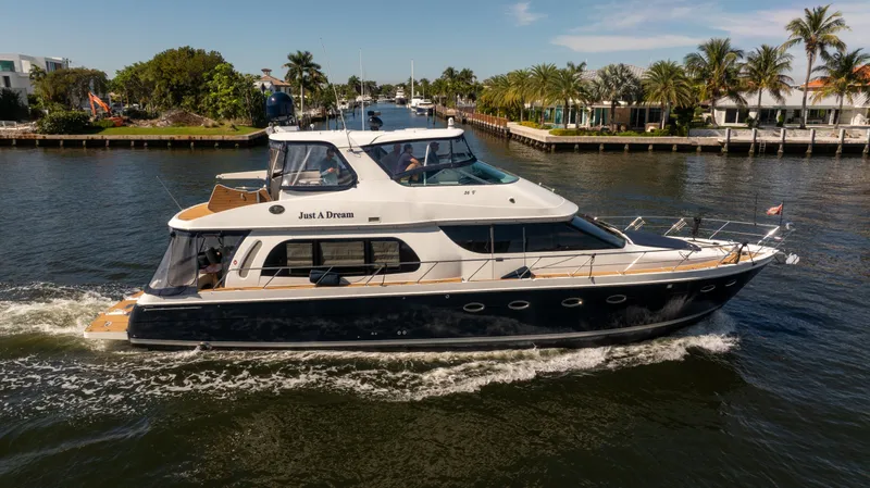 Slide: The Image of 2005 Carver 56 Voyager yacht cruising on a scenic waterway with palm trees. - 6