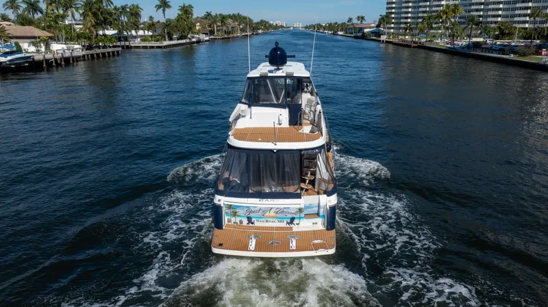 Slide: The Image of 2005 Carver 56 Voyager yacht cruising on a scenic waterway with palm trees. - 8