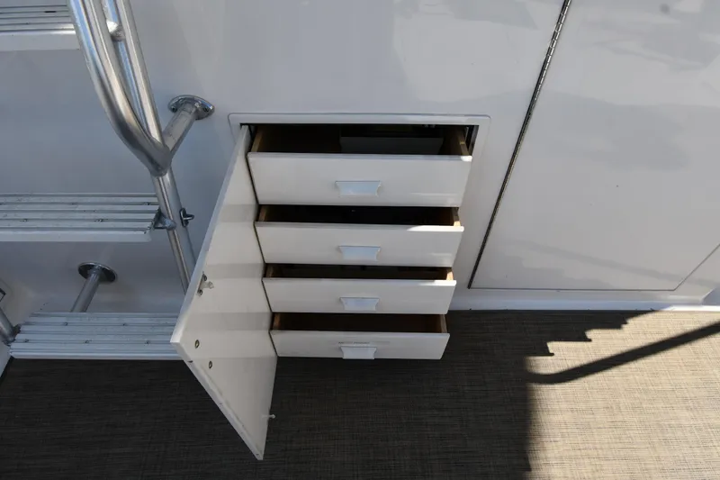 Slide: The Image of Open storage drawers on a 1996 Viking 53 Convertible yacht, next to metal steps. - 16