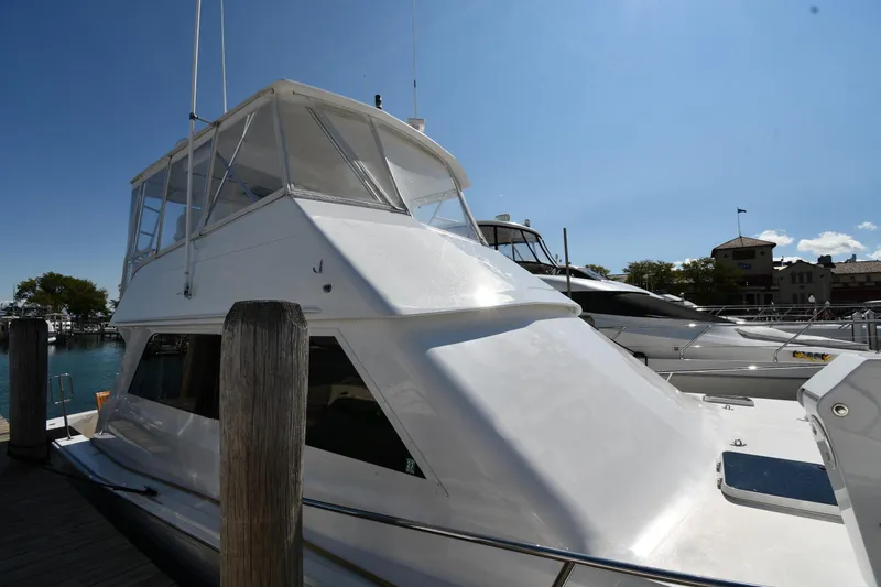 Slide: The Image of 1996 Viking 53 Convertible yacht docked under clear blue sky. - 2