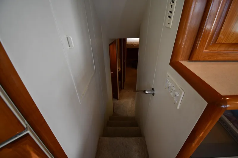 Slide: The Image of Interior view of 1996 Viking 53 Convertible yacht, showing narrow staircase and wooden cabinetry. - 38
