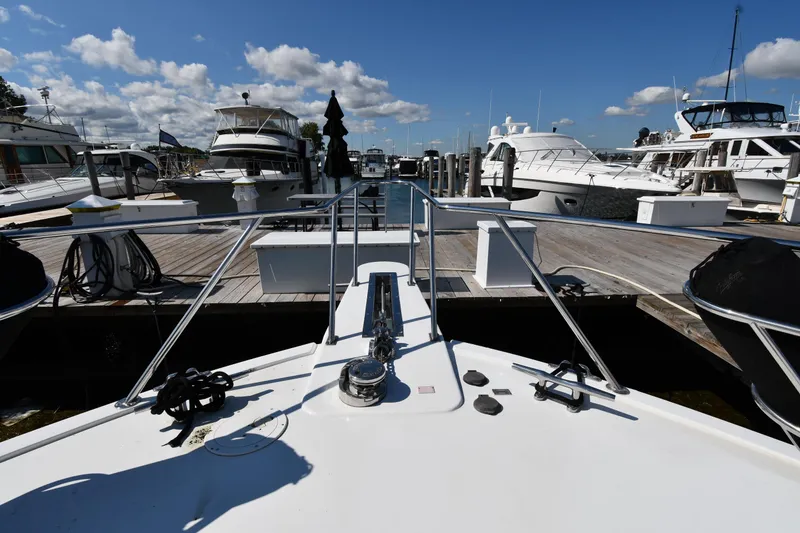 Slide: The Image of Bow view of a 1996 Viking 53 Convertible yacht docked at a marina. - 4
