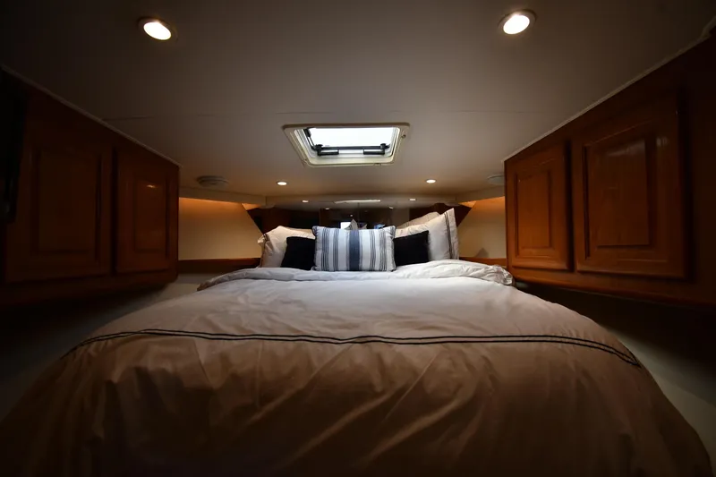 Slide: The Image of Cozy bedroom interior of 1996 Viking 53 Convertible yacht with wooden cabinets and skylight. - 40