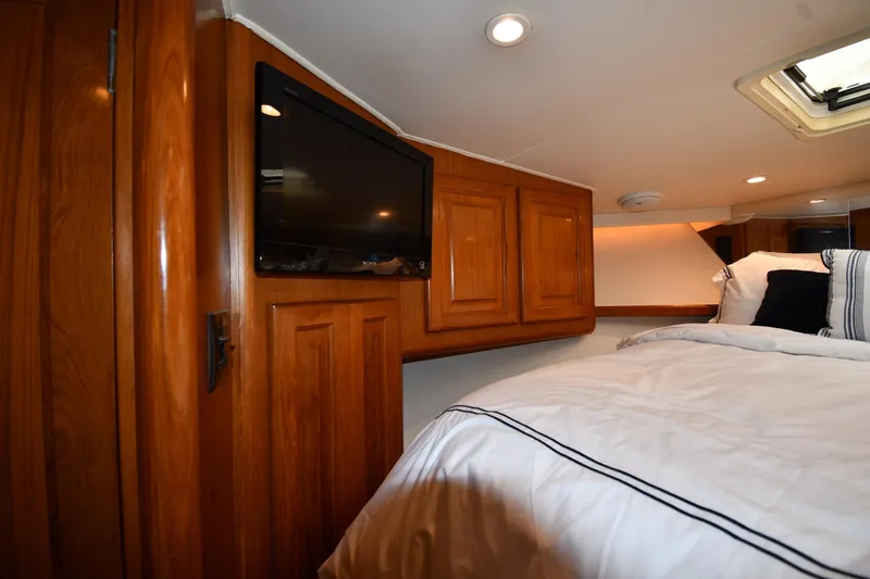 Slide: The Image of Interior of 1996 Viking 53 Convertible yacht with wood cabinetry and cozy bedding. - 42