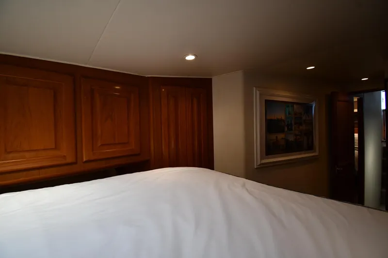 Slide: The Image of Interior of 1996 Viking 53 Convertible yacht bedroom with wood paneling and framed artwork. - 44