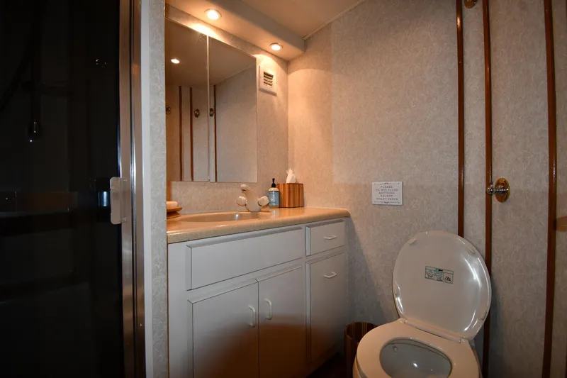 Slide: The Image of Bathroom interior of 1996 Viking 53 Convertible yacht with sink, mirror, and toilet. - 48
