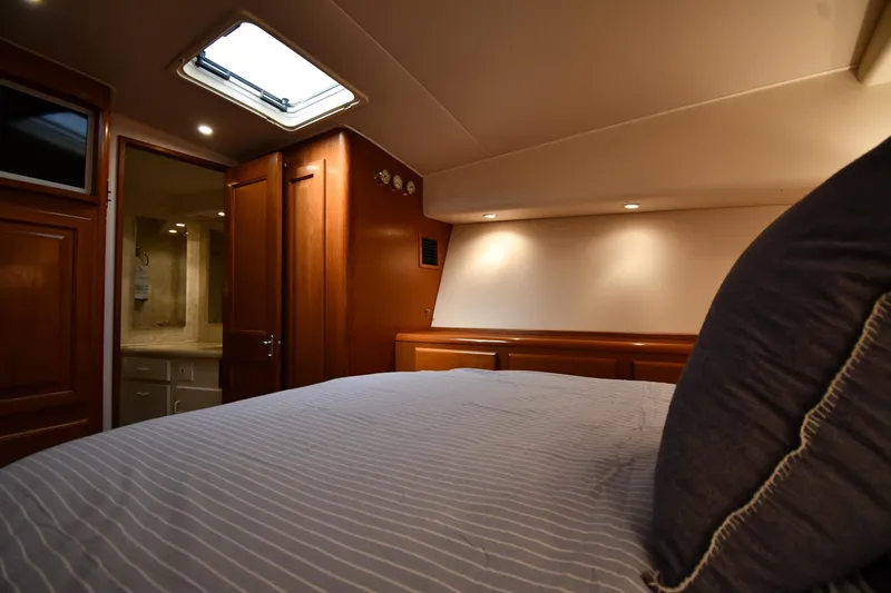 Slide: The Image of Interior of 1996 Viking 53 Convertible yacht bedroom with wooden cabinetry and skylight. - 57