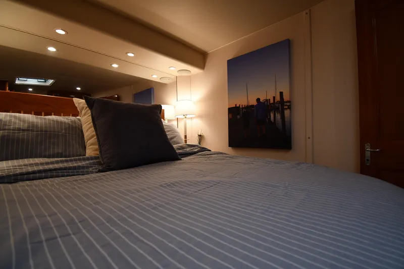 Slide: The Image of Cozy bedroom interior on 1996 Viking 53 Convertible yacht with striped bedding and wall art. - 58