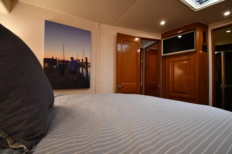 Slide: The Image of Luxurious bedroom interior of 1996 Viking 53 Convertible yacht with wooden accents. - 59