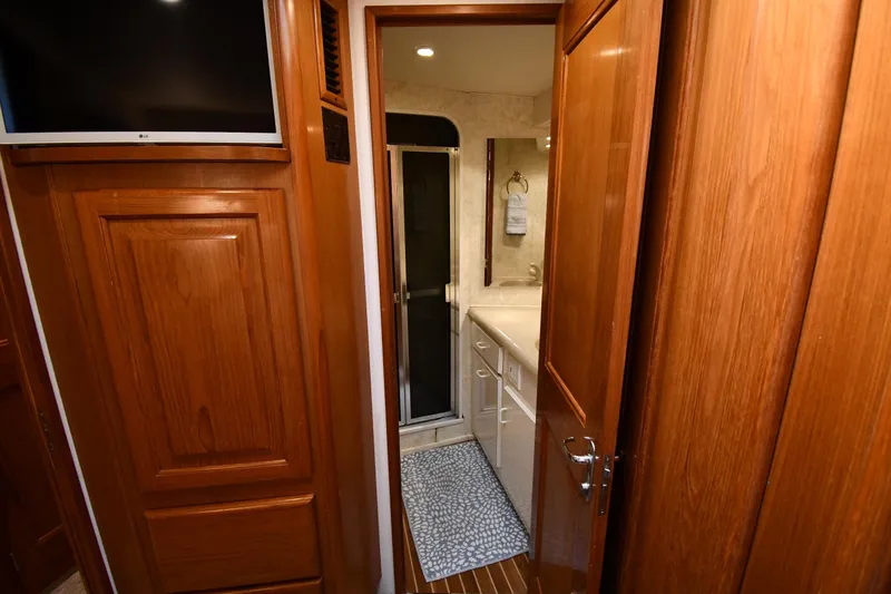 Slide: The Image of Interior of 1996 Viking 53 Convertible yacht, featuring wooden cabinetry and a compact bathroom. - 60
