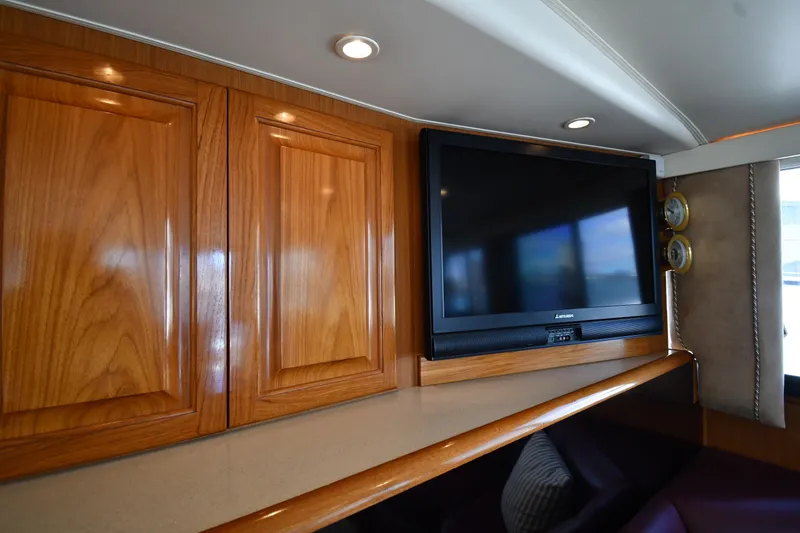 Slide: The Image of Interior of 1996 Viking 53 Convertible with wooden cabinets and a mounted TV. - 71