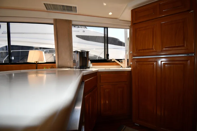 Slide: The Image of Interior of 1996 Viking 53 Convertible yacht with wooden cabinetry and modern kitchen amenities. - 73