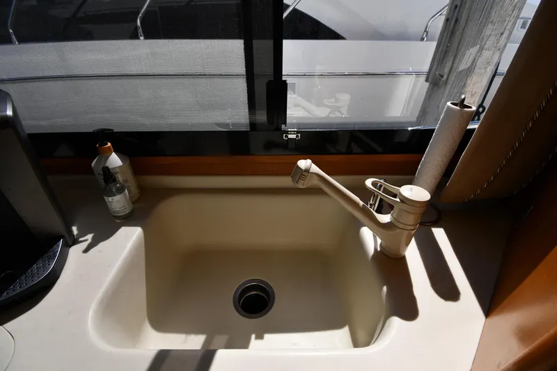 Slide: The Image of Kitchen sink area on a 1996 Viking 53 Convertible yacht with faucet and soap. - 74