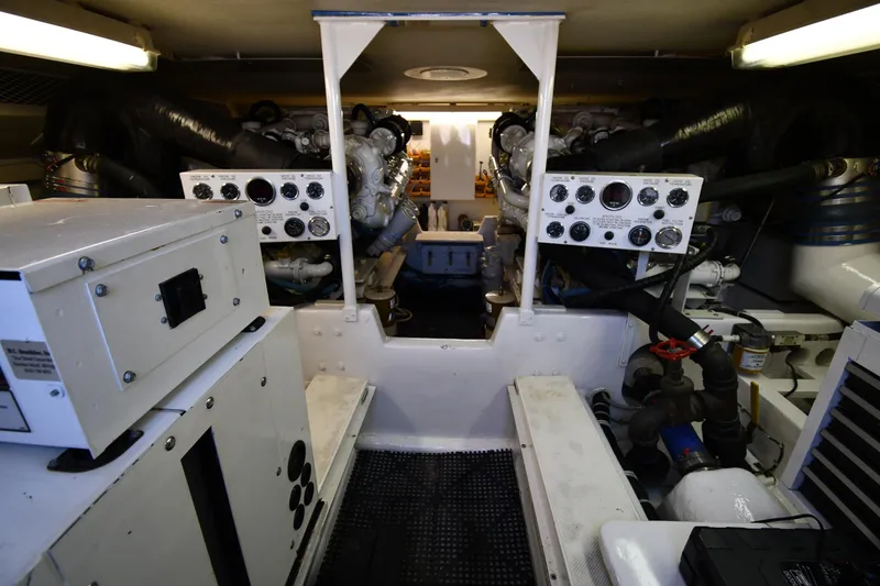 Slide: The Image of Engine room of a 1996 Viking 53 Convertible yacht, showcasing control panels and machinery. - 84