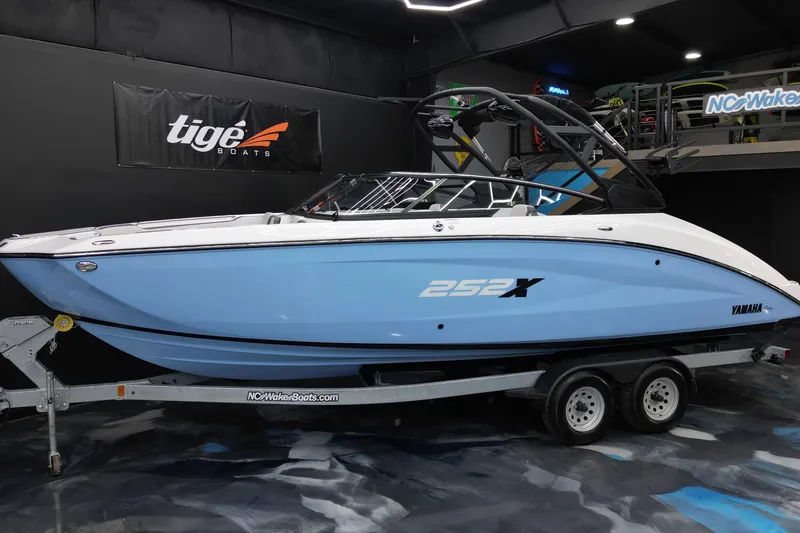 Slide: The Image of 2024 Yamaha Boats 252XE in showroom, sleek design, blue and white color scheme. - 19