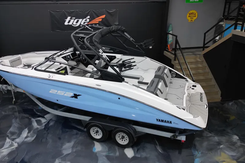 Slide: The Image of 2024 Yamaha Boats 252XE in showroom, sleek design, blue and white color scheme. - 8