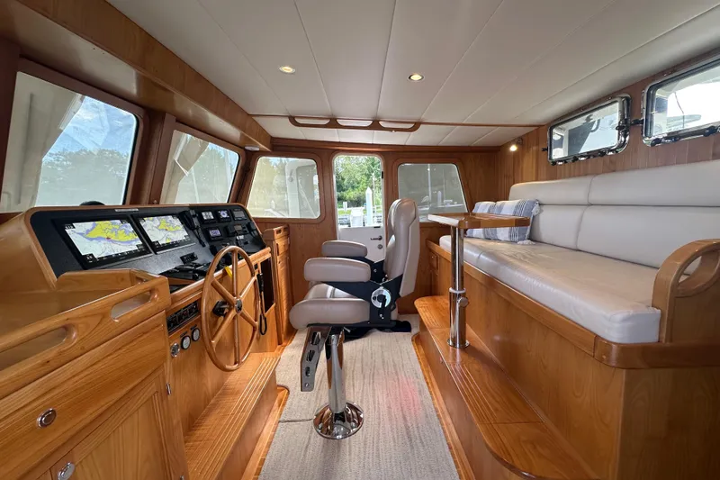 Slide: The Image of 2021 Kadey-Krogen 44AE yacht interior with navigation equipment and seating area. - 12