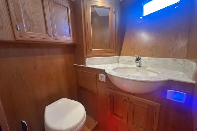 Slide: The Image of Luxurious 2021 Kadey-Krogen 44AE yacht bathroom with wood cabinetry and marble sink. - 23