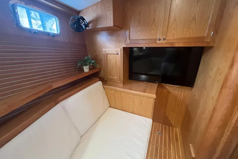 Slide: The Image of Interior of 2021 Kadey-Krogen 44AE yacht with wood paneling, sofa, TV, and porthole window. - 25