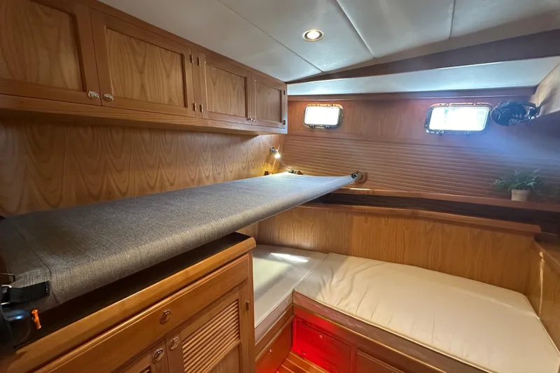 Slide: The Image of Cozy cabin interior of 2021 Kadey-Krogen 44AE with wooden cabinetry and porthole windows. - 26